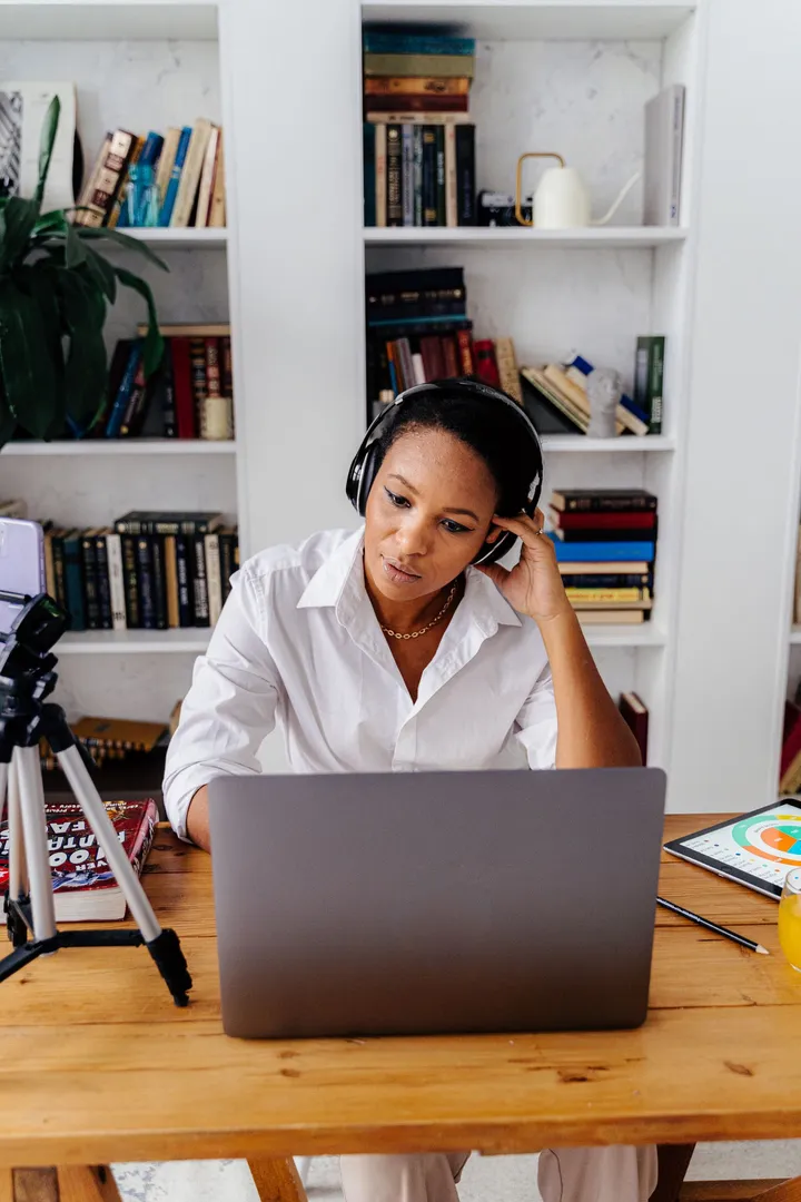 A woman at a desk at home, on a video call on her laptop